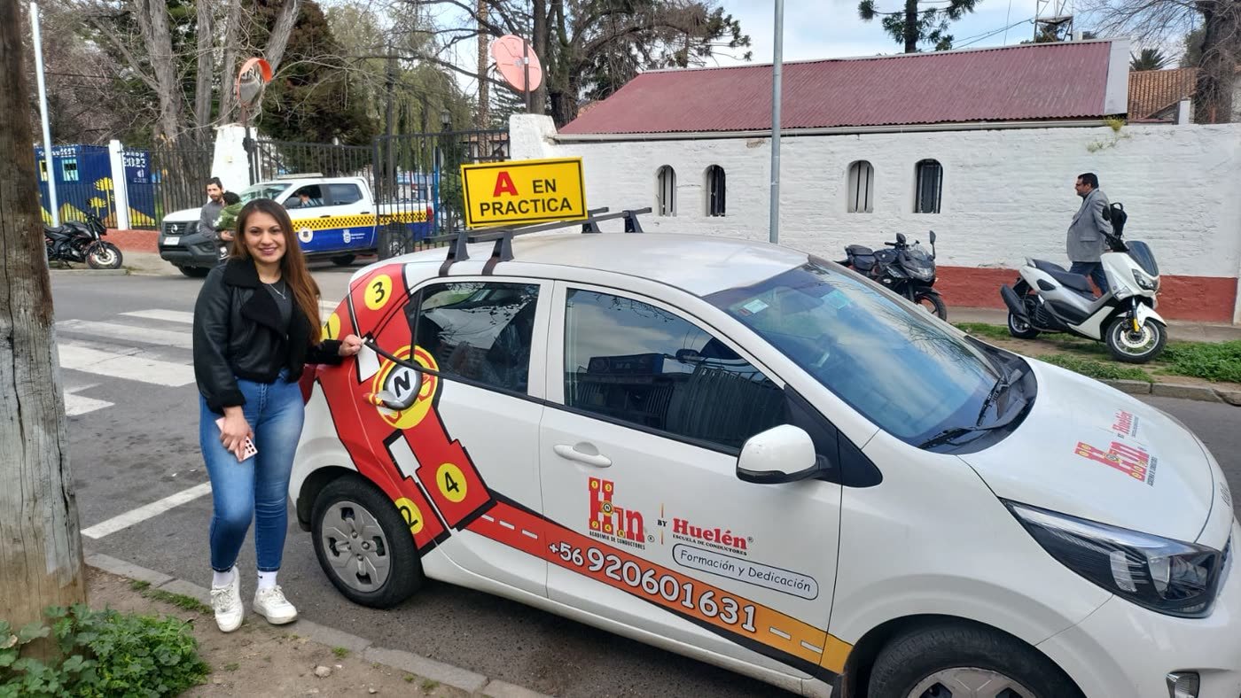 Alumna junto al auto de práctica de la academia